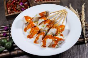 Skewered Tilapia slice boil for 1 minute and pair with spicy sauce
