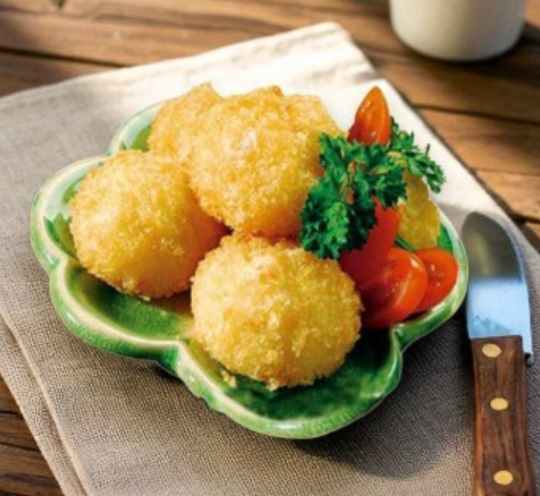 A plate of ready-to-cook breaded scallops with golden coating.