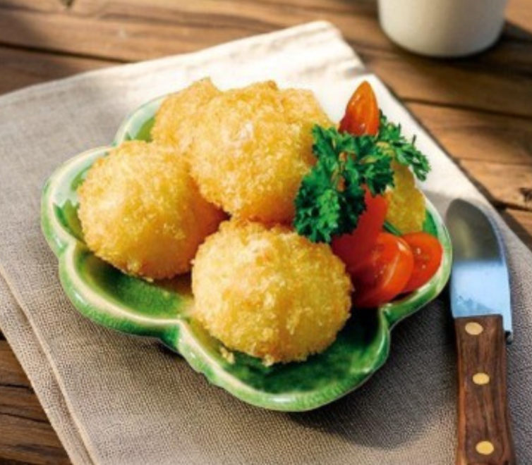 A plate of ready-to-cook breaded scallops with golden coating.